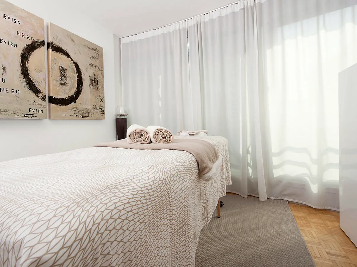 Massageraum mit vorbereiteter Liege und Handtüchern